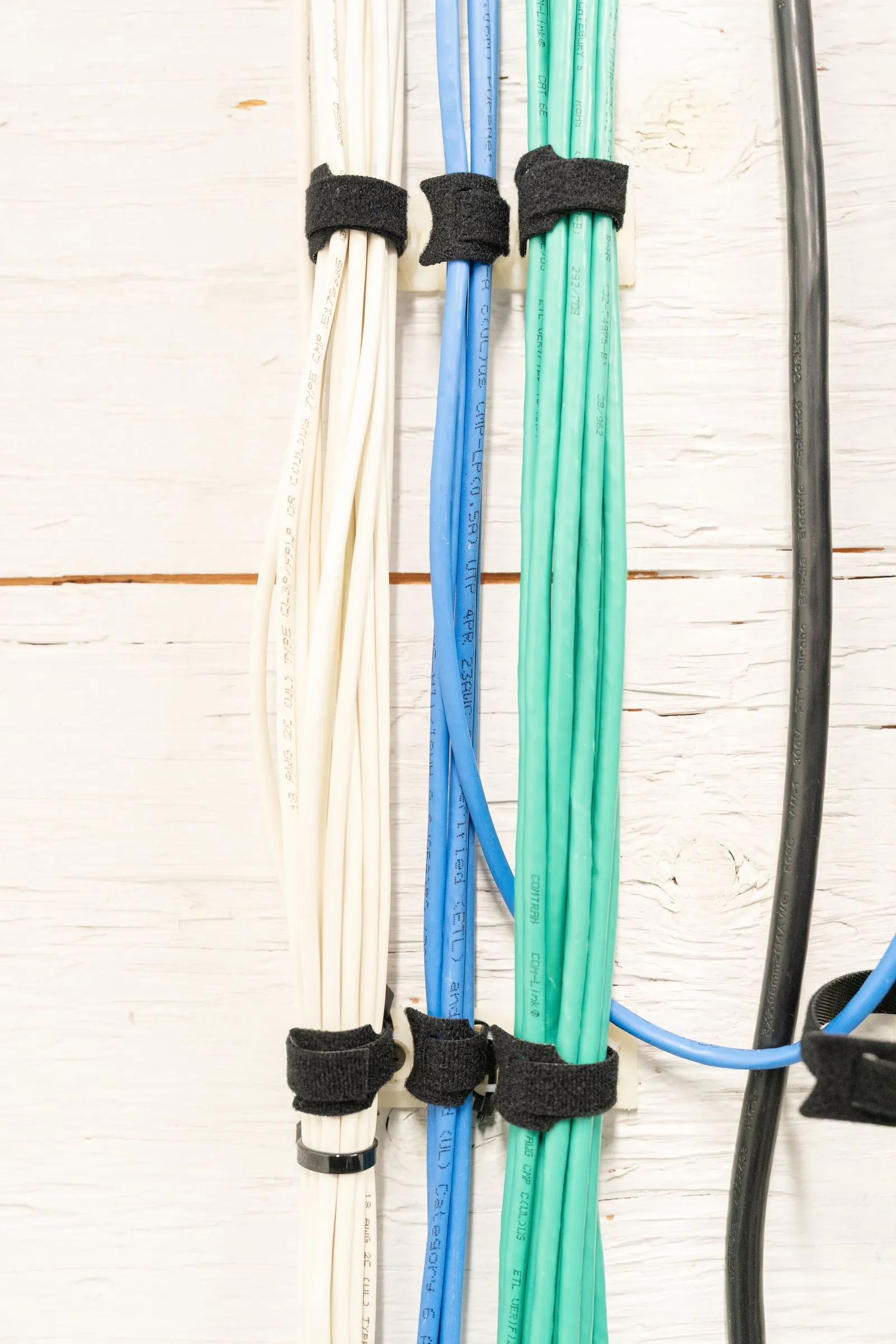 Velcro-bundled network cables running down a wall