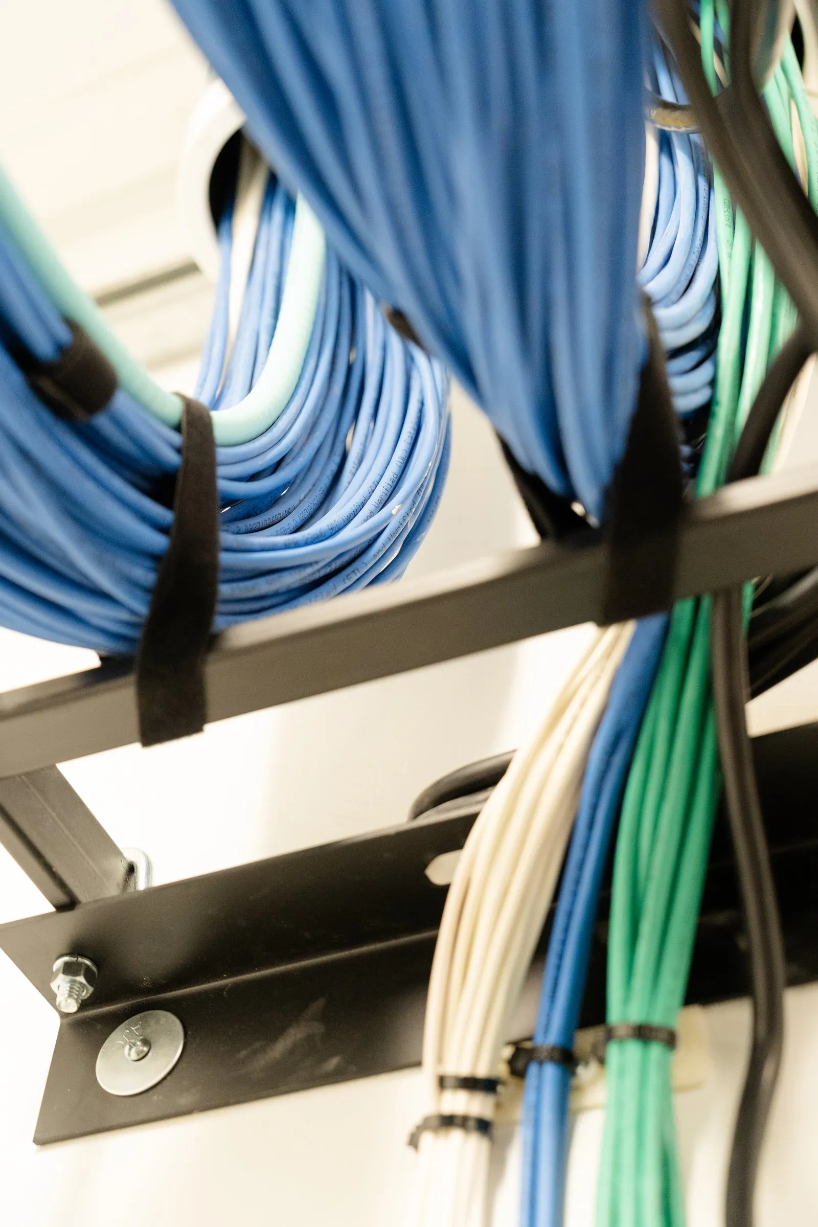 Organized copper cable runs dropping from a cable tray