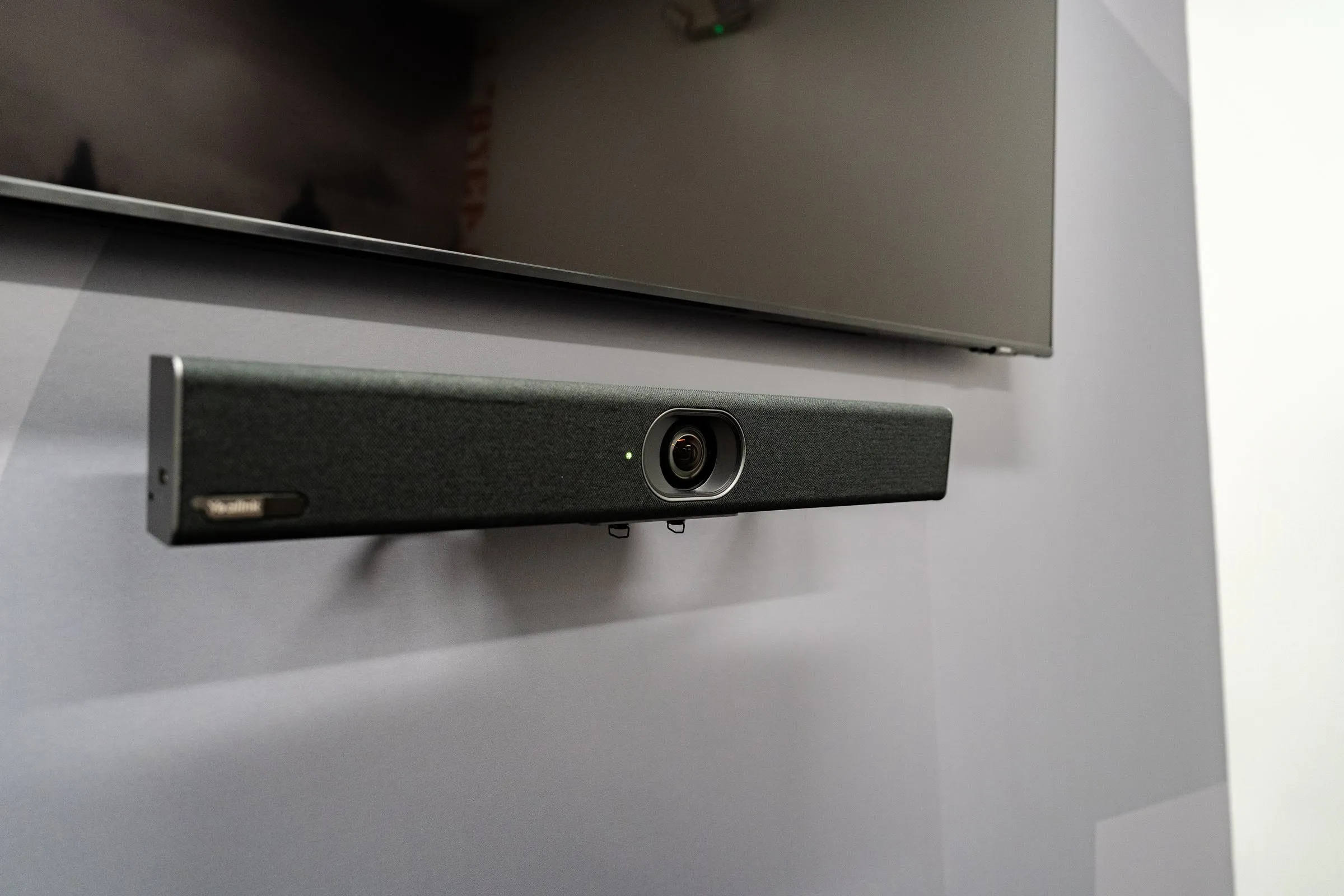 Video conferencing bar mounted below a meeting room display