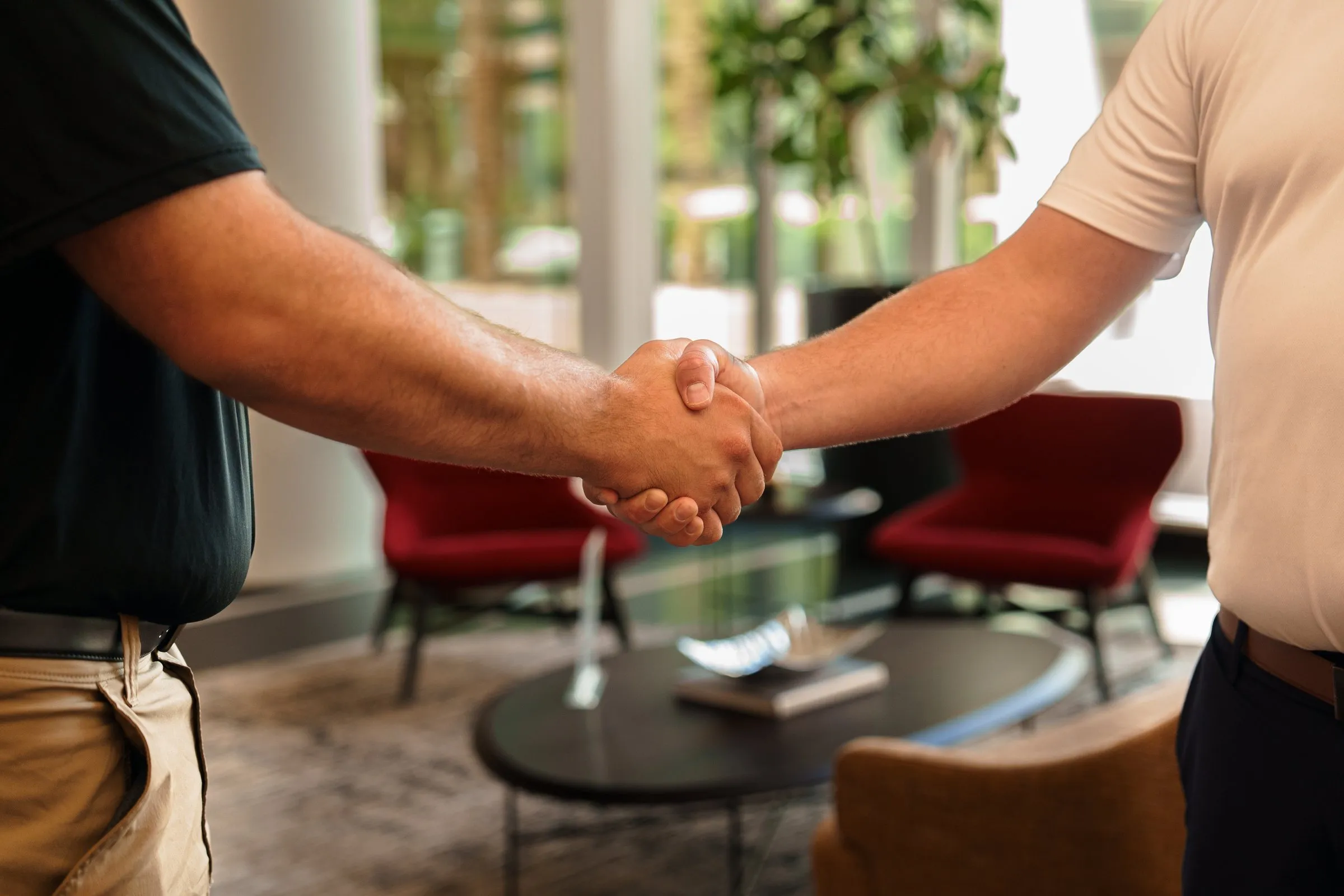 AJTC team member shaking hands with a client in the Phoenix office lobby