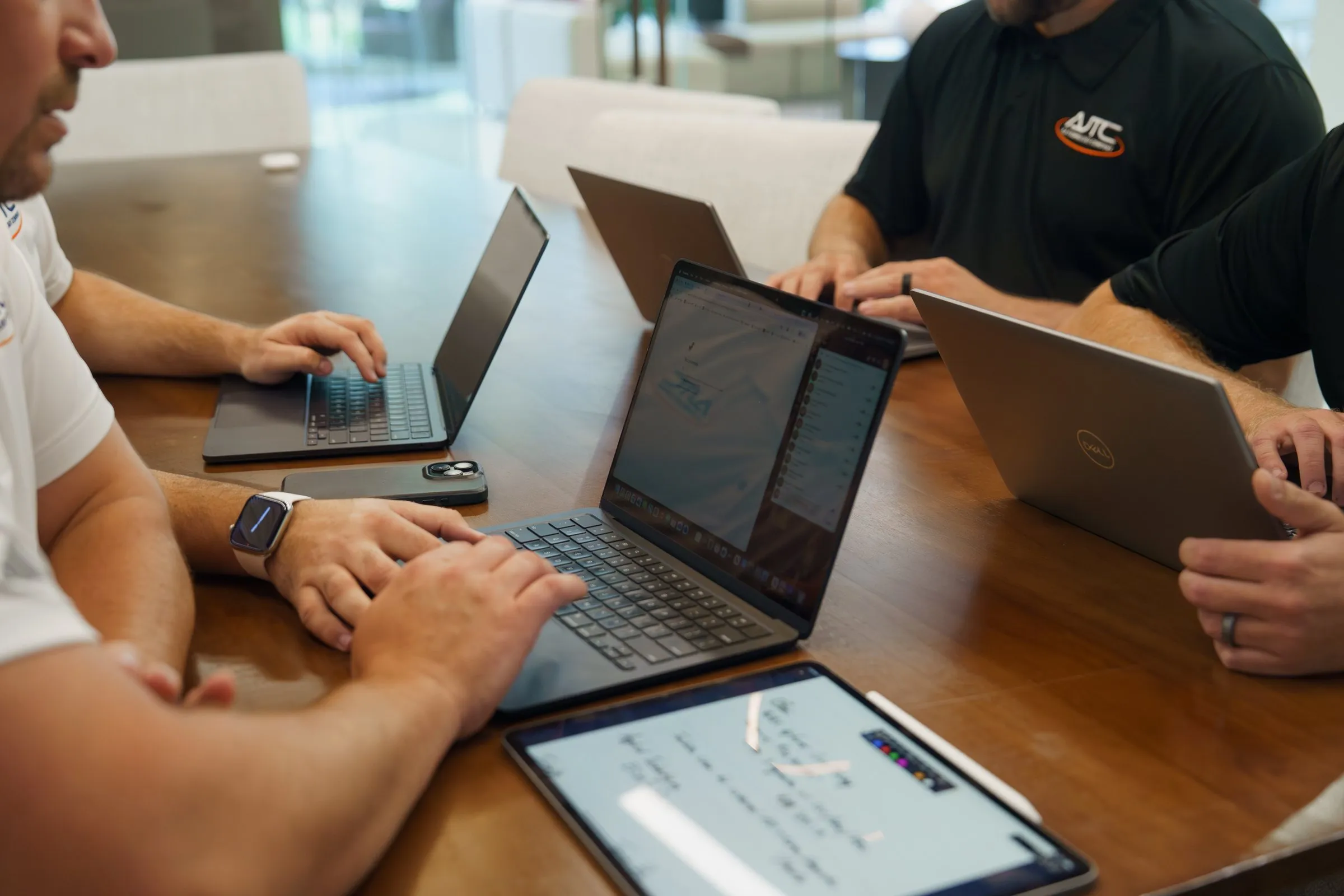 AJTC Phoenix team working through a client project on laptops